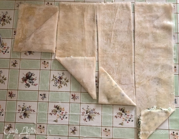 Завернуть краешек треугольником. Продолжайте заворачивать тесто треугольником до конца полоски. Так же поступите с остальным тестом и начинкой.