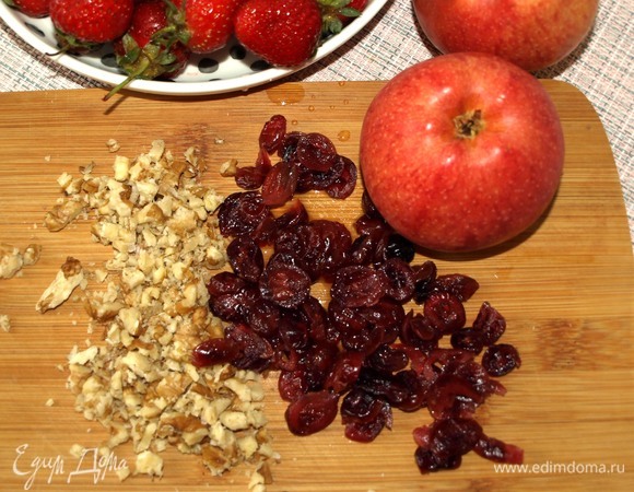 Клюкву замочить на 10 минут в теплой воде, слить воду, промыть и просушить бумажными полотенцами. Орехи мелко порубить. Яблоки очистить и нарезать мелкими кубиками.
