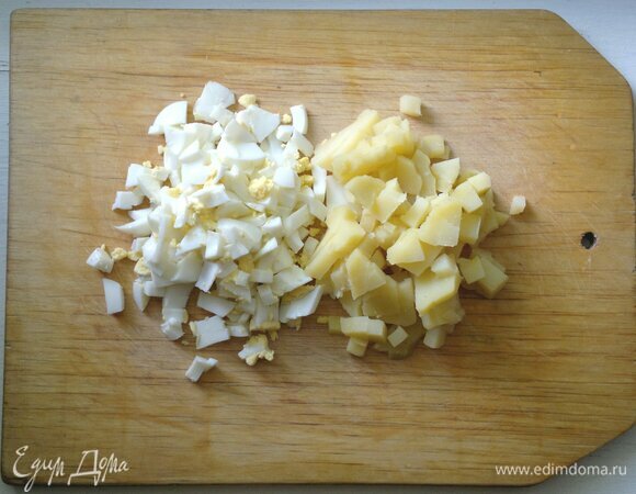 Яйца почистить, у одного яйца вынуть желток, отложить. Картофель и яйца нарезать небольшими кубиками.