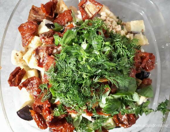 Нарежьте помидоры (у меня банка весом нетто 270 г, я взяла половину банки) и травы и добавьте к салату вместе с кедровыми орешками и фетой.