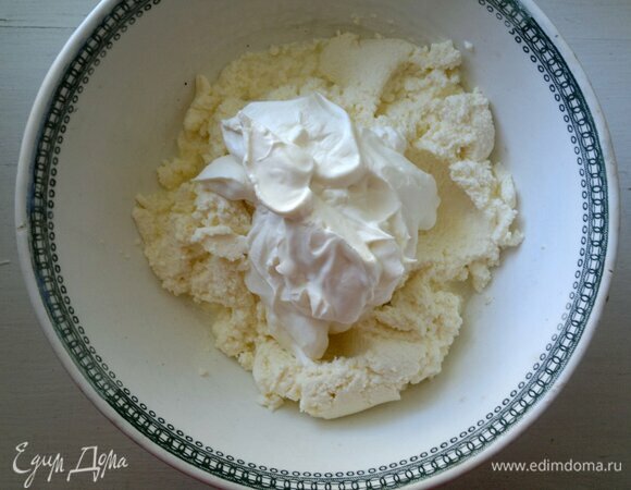 К творогу добавить сметану, перемешать до однородности.