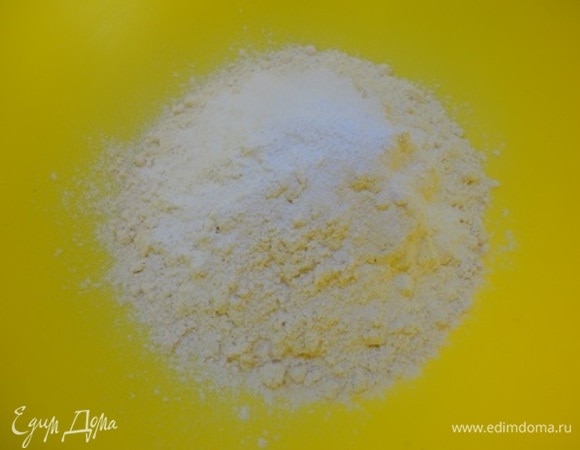 Включить духовку для разогрева на 180°C. Подготовить форму диаметром 18–20 см: дно выстлать пекарской бумагой, а бока смазать сливочным маслом. Смешать кукурузную муку с разрыхлителем и щепоткой соли.