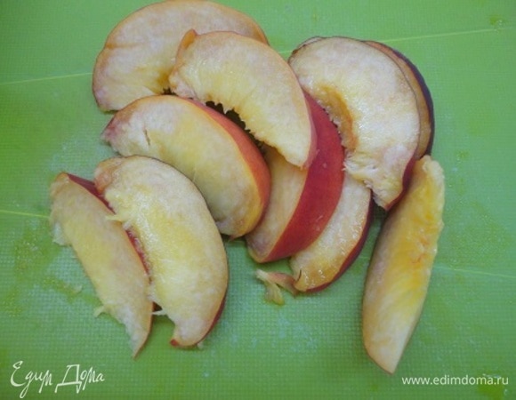 Из крупного персика удаляем косточку, нарезаем его на дольки.