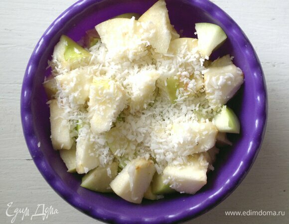 Для пирога я брала 1 крупное яблоко, можно взять 2 средних. Яблоко вымыть, обсушить, разрезать пополам, удалить семенную коробочку. Нарезать яблоко небольшими ломтиками, соединить с кокосовой стружкой, перемешать.