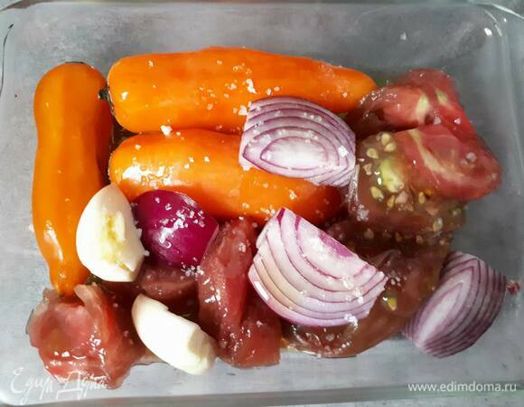 Разрежьте помидор и лук на части. Раздавите чеснок. Выложите все вместе с перцем чили в форму для запекания, сбрызните оливковым маслом, посолите и отправьте в духовку на 20 минут.