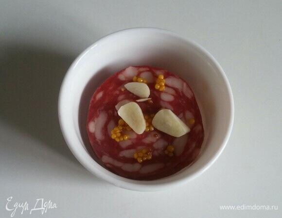 Для того чтобы колбаса пропиталась ароматом горчицы и чеснока, нужно сложить ее в пиалу, накрыть пищевой пленкой и убрать в холодильник на 15–20 минут.