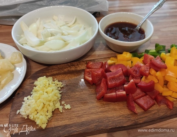 Подготовить продукты: лук нарезать перьями. Из перцев удалить сердцевину и перепонки, нарезать небольшими кусочками. Имбирь очистить и натереть на терке или мелко нарезать. Чеснок мелко нарезать. Нарезать зеленый лук и ананас (консервированный, понадобятся 2–3 шайбочки) небольшими кусочками. Для соуса смешайте в миске кетчуп, уксус, соевый соус и сахар.