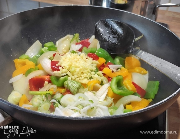 Разогреть в воке 2 столовые ложки масла, добавить лук и обжарить 2 минуты, помешивая. Добавить перец и обжаривать еще 3 минуты. Выложите в сковороду ананас, имбирь, чеснок и зеленый лук и жарьте все вместе в течение одной минуты.