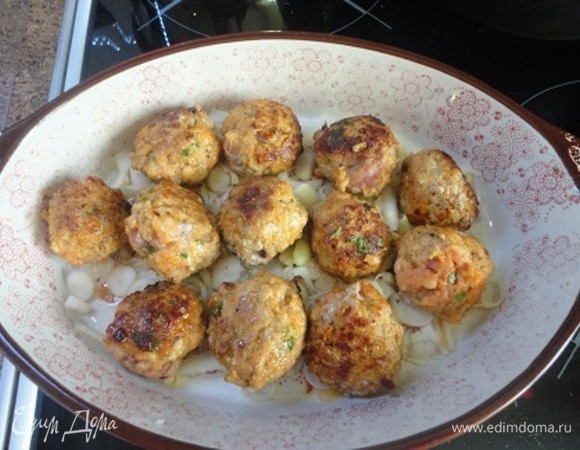 Лук и чеснок мелко порубите и выложите с пряностями и вином на дно формы для запекания. Сверху — фрикадельки.