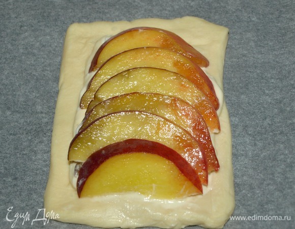 Небольшие твердые персики хорошо вымыть, просушить, разрезать на две части и удалить косточку. Нарезать персик слайсами. Выкладываем слайсы на сырную начинку.