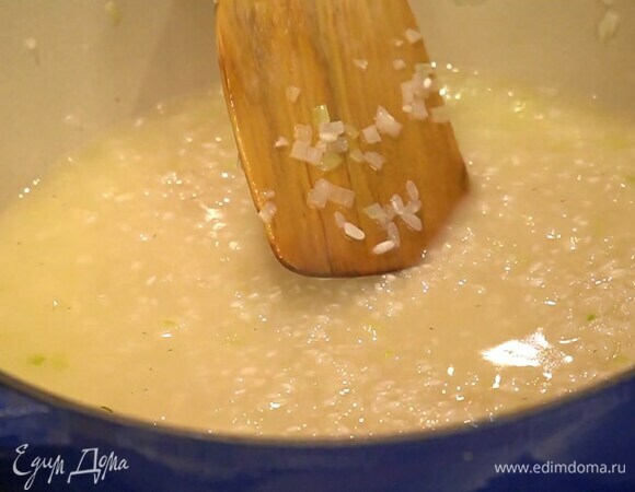 Влить к рису 150 мл вина, на большом огне дать алкоголю выпариться, затем убавить огонь и готовить около 15 минут, по половнику вливая горячий бульон, так чтобы рис не плавал в жидкости, но и не превратился в ком.