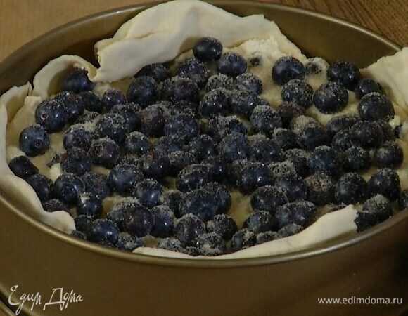 Тесто поместить в разъемную форму для выпечки, так чтобы получились бортики, выложить творожную начинку, сверху украсить оставшимися ягодами, посыпать сахаром.