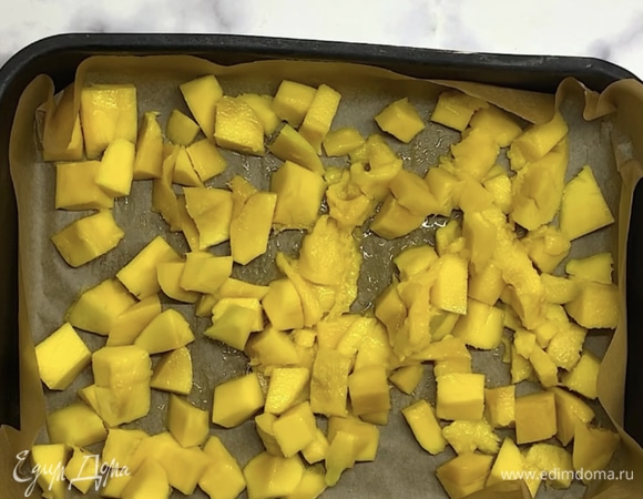 Выкладываем в форму или маленький противень, застеленный бумагой для выпечки. Распределяем кусочки манго, чтобы они легли равномерным слоем. Накрываем пищевой пленкой и убираем в морозилку на 3–4 часа или на ночь.