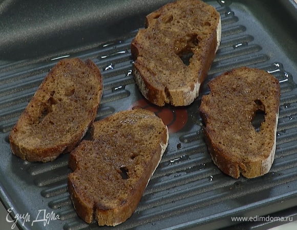 Хлеб нарезать кусочками и поджарить с одной стороны на сухой сковороде-гриль, затем полить сверху 1 ст. ложкой оливкового масла, перевернуть, снова сбрызнуть маслом и жарить до появления золотистых полосок.