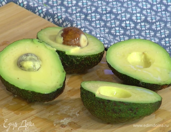 Авокадо разрезать пополам, удалить косточки, мякоть сбрызнуть лимонным соком.