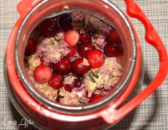 В подходящую емкость отправить клюкву (если клюква замороженная, то размораживать ее не надо), цветы чайной розы, джем или варенье из розы. Залить 200 мл кипяченой воды и примять клюкву, так чтобы она дала сок. Залить оставшейся кипяченой водой. Вода должна быть горячей. Дать остыть настою и отправить в холодильник на 8 часов (можно больше).