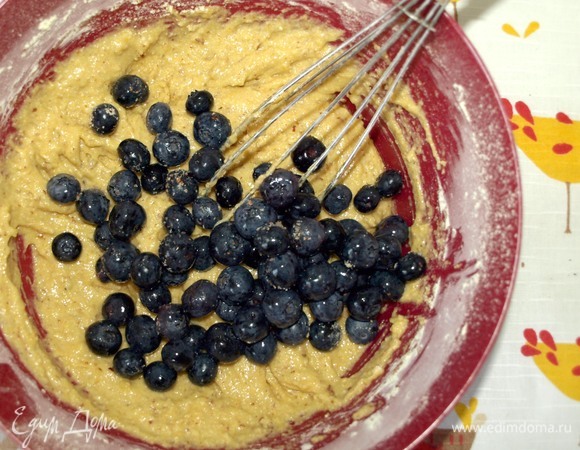 Добавляем в миску с тестом голубику. Аккуратно вмешиваем голубику в тесто.