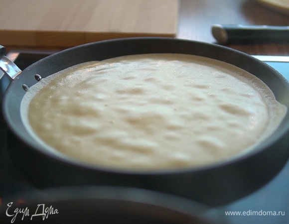 Блинную сковороду поставьте на огонь. Смажьте тонким слоем оливкового масла. Испеките блины.