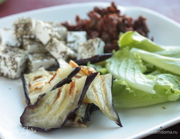 Готовые вяленые томаты можно добавить в салат целиком, а можно их измельчить и, например, смешать с оливками. Готовые баклажаны нарежьте на несколько частей. Салат промойте и порвите руками. Для заправки смешайте оливковое масло из-под вяленых томатов с бальзамическом соусом, добавьте немного лимонного сока, поперчите и посолите по вкусу.