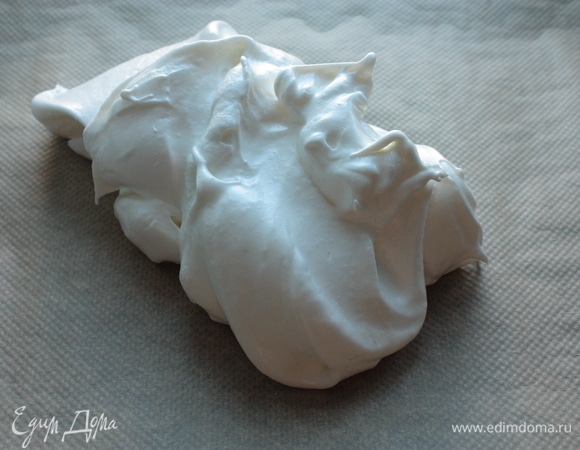 Меренгу выложите на пергамент для выпечки (не нужно его ничем смазывать) и равномерно распределите по противню достаточно толстым слоем.