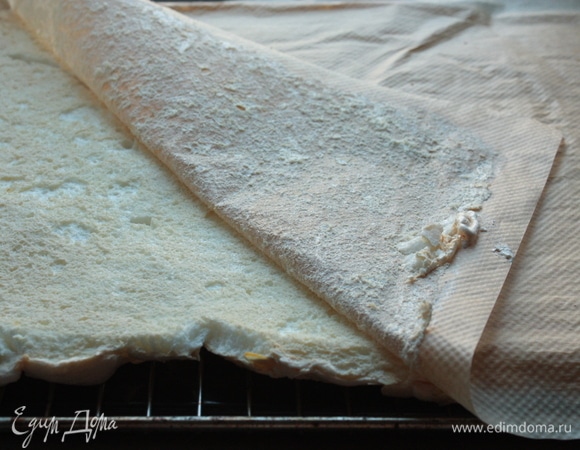 Аккуратно накройте меренгу вторым пергаментом, переверните и удалите нижний слой пергамента, пока меренга не остыла. После чего оставьте ее остывать до комнатной температуры.