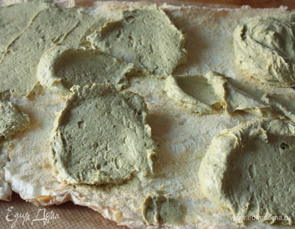 Когда меренга полностью остынет, начинаем собирать рулет. Для этого на перевернутую меренгу выкладываем крем и равномерно его распределяем.