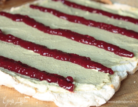 Малиновую начинку перекладываем в конверт и выкладываем поверх крема: самая первая порция идет впритык с краем, с которого будет сворачивать рулет, далее выкладываем еще несколько порций. На сторону, где будет конец рулета, начинку не наносим. По желанию еще можно добавить в начинку свежую малину — тоже получается прекрасно!