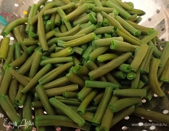 Стручковую фасоль опустить в кипящую воду с добавлением щепотки соли. Варить 5–6 минут, после чего откинуть на дуршлаг и промыть под проточной водой.