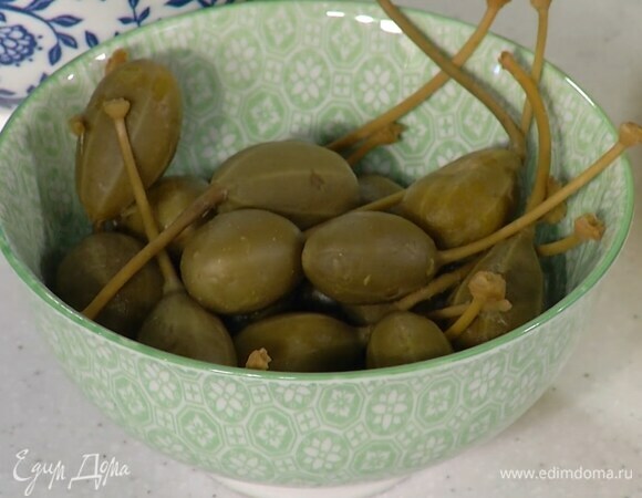 Каперсы разрезать вдоль пополам.