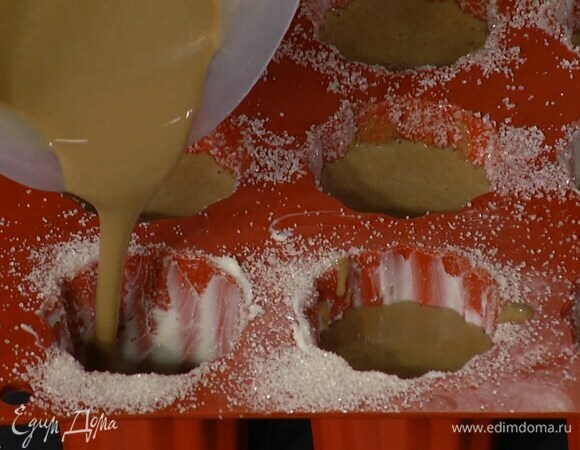 Формы для канеле смазать оставшимся сливочным маслом, посыпать сахаром и наполнить тестом на 2/3 объема.