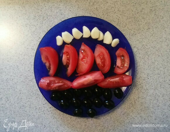 Зубчики чеснока и маслины нужно разрезать пополам, а помидор — на 8 равных частей.