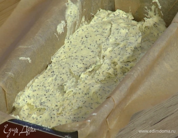 Форму для кекса застелить бумагой для выпечки, выложить тесто и равномерно распределить.