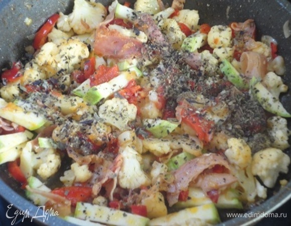 Добавить овощи, посолить, поперчить, добавить сухой базилик и продолжить жарить на среднем огне до мягкости овощей.