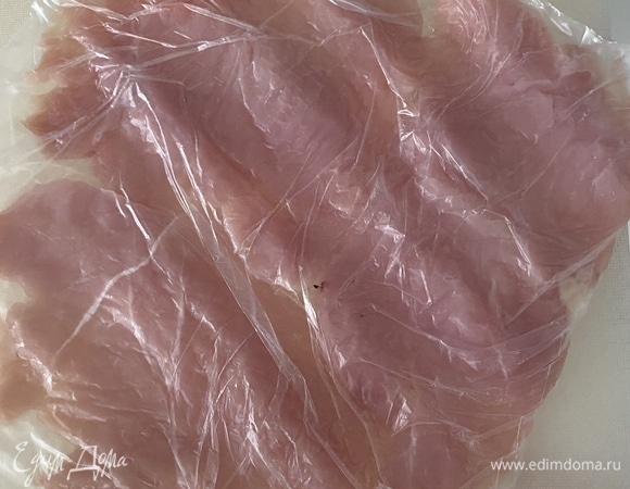 Филе индейки нарезать на стейки толщиной 0,5 см. Сложить в пакет и отбить скалкой до толщины 2–3 мм. В размере кусочки филе увеличатся почти вдвое.