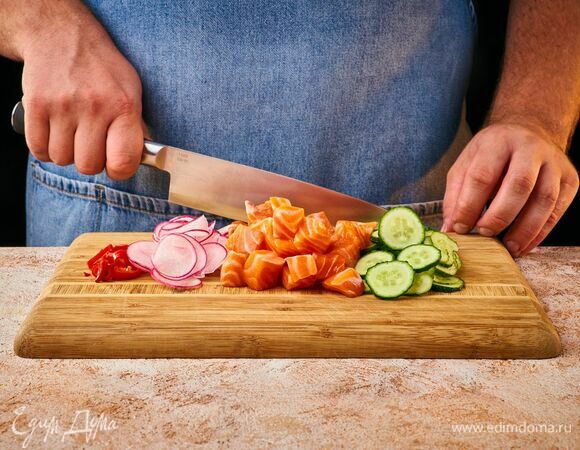 Нарежьте лосося аккуратными крупными кубиками. Редис, огурец и перец чили нарежьте тонкими кружками. 