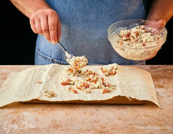 На лаваш выложите начинку и распределите по поверхности.