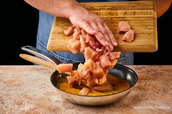 На разогретую сковороду влейте масло, выложите пасту карри и обжаривайте около минуты, пока не раскроется аромат специй. Выложите курицу и обжарьте.