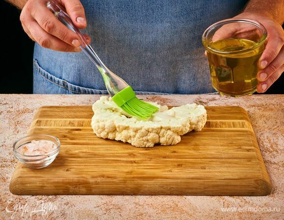 Промойте кочан капусты и разрежьте на стейки. Толщина их должна быть не менее 1,5–2 см, чтобы капуста не рассыпалась. Смажьте стейк оливковым маслом и посолите.