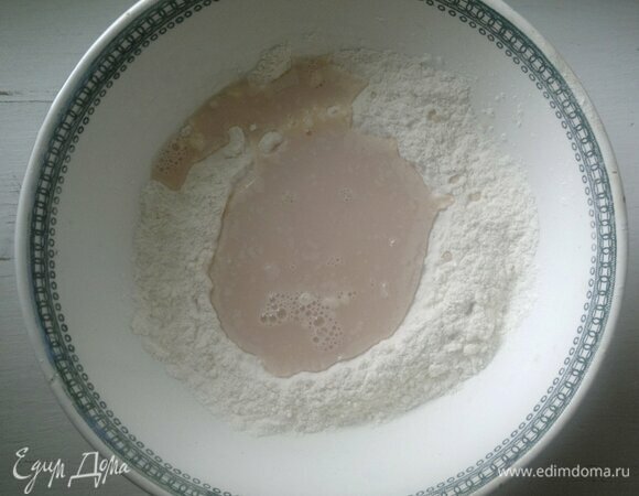 К сухим ингредиентам влить воду с дрожжами, растительное масло, замесить тесто.