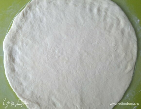 На подпыленной мукой поверхности раскатать тесто в тонкий круг, оставляя небольшой бортик (примерно 1 см).