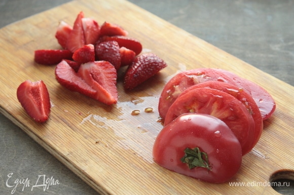 Для этого салата лучше брать спелые сладкие помидоры (на 4 порции достаточно 2 средних штук). Нарежьте их поперек, а не вдоль. У клубники удалите хвостики и разрежьте клубнику на 6–8 долек в зависимости от размера ягоды.
