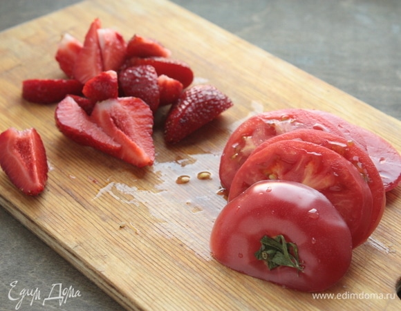 Для этого салата лучше брать спелые сладкие помидоры (на 4 порции достаточно 2 средних штук). Нарежьте их поперек, а не вдоль. У клубники удалите хвостики и разрежьте клубнику на 6–8 долек в зависимости от размера ягоды.