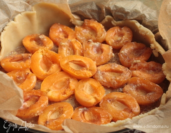 Поверх теста выложите франжипановую начинку и сверху расположите абрикосы.