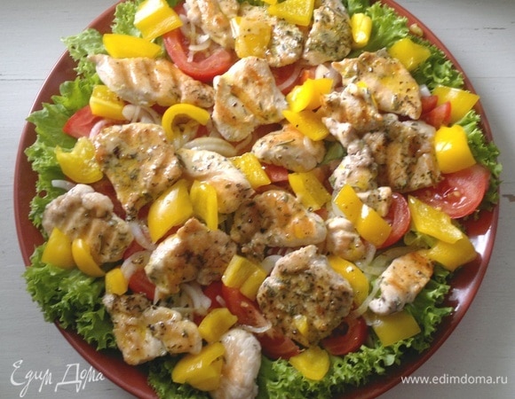 Полить салат заправкой. Посыпать листьями руколы.