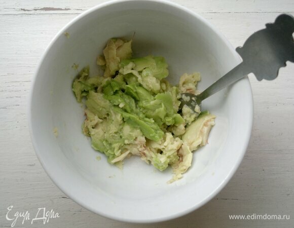 Плод авокадо должен быть спелым. Необходимо вымыть его и обсушить. Разрезать авокадо пополам, удалить косточку. Ложкой вынуть мякоть из половинок авокадо, положить в миску, полить лимонным соком, перемешать.