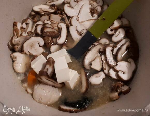 Влейте мисо в горячий бульон (можно взять рыбный или овощной кубик), хорошо перемешайте и доведите до кипения. Добавьте тофу (без воды), очищенные морские гребешки и шиитаке, посолите и оставьте вариться на среднем огне примерно 5 минут.