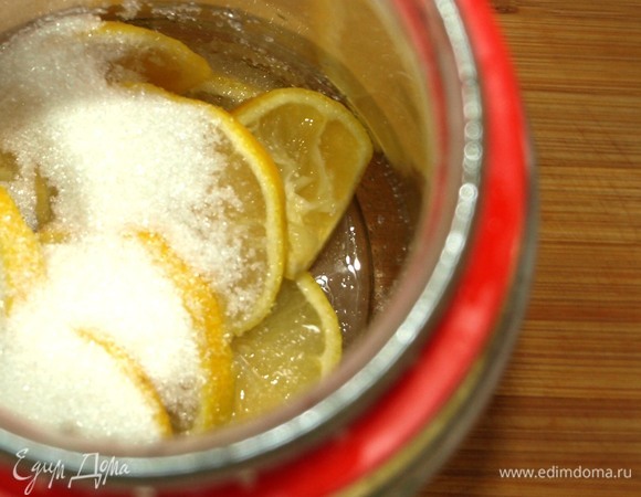 Завариваем черный чай. Лимоны нарезаем кружочками, отправляем в банку и засыпаем сахаром.