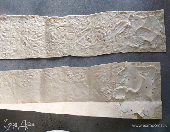 Лист лаваша нарезать на 4 полоски. Край смазать творожным сыром. У меня с зеленью.