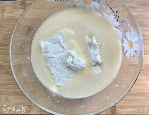Добавить творог и взбить миксером. Ввести просеянную муку с разрыхлителем, перемешать.