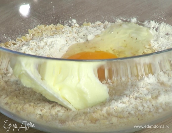 Приготовить тесто: овсянку, грецкие орехи и муку поместить в глубокую миску, добавить яйцо и предварительно размягченное сливочное масло, все перемешать, всыпать соль, тимьян и вымесить тесто руками.